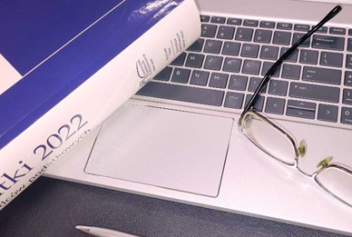 Segregator, laptop i okulary pracownika biura rachunkowego